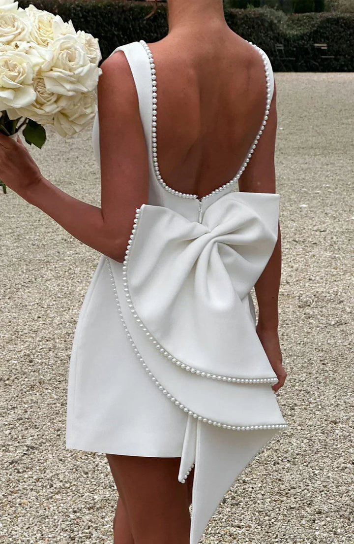 Robe courte femme en coton, dotée d'un nœud décoratif au dos et d'une coupe fluide pour un look décontracté.
