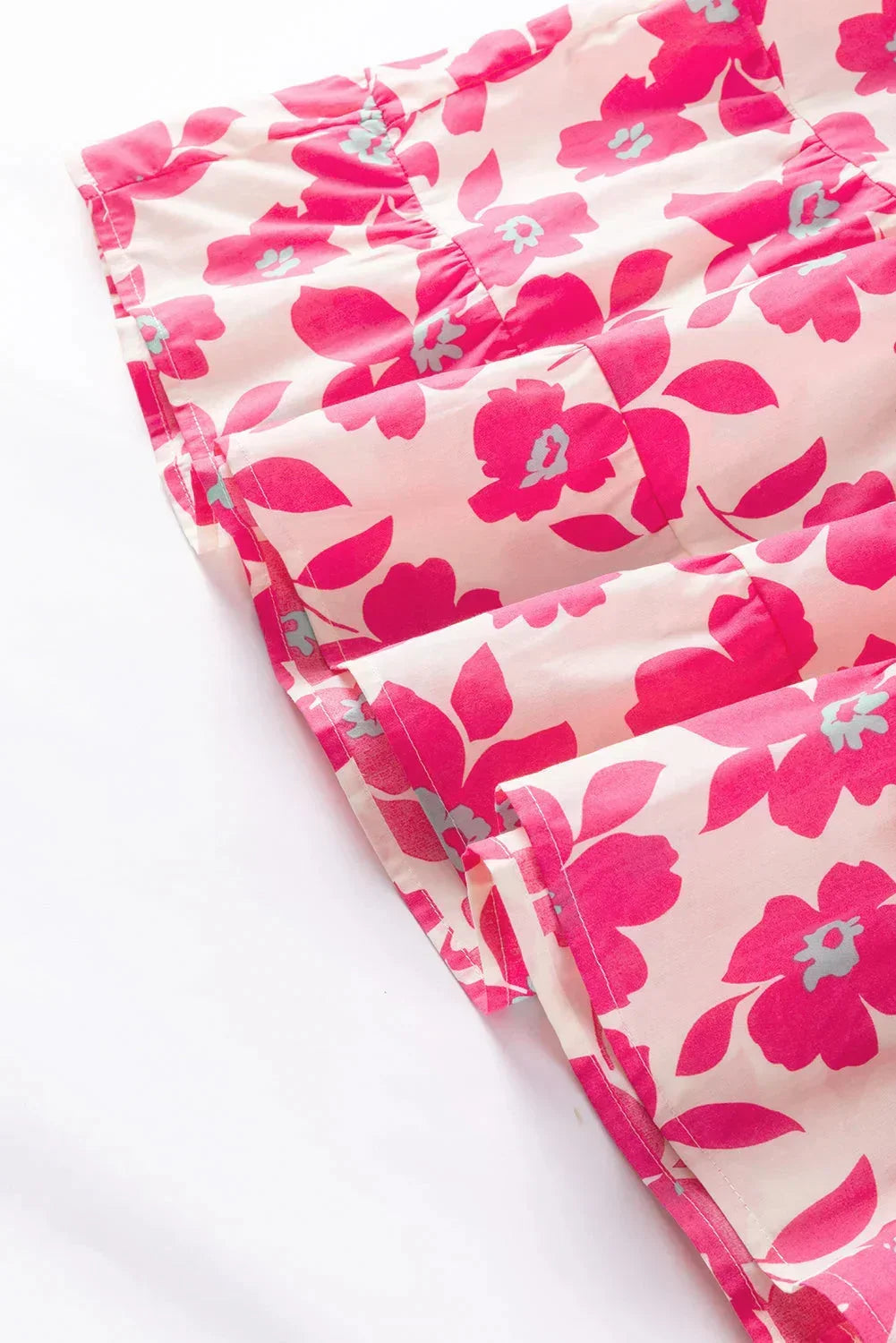 Robe courte fleurie rose, en coton léger, avec volants et manches bouffantes, idéale pour des journées d'été décontractées.