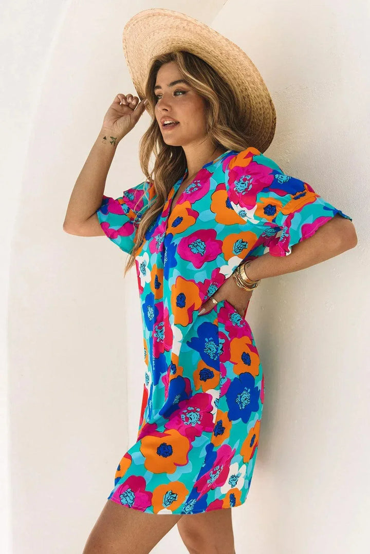 Robe courte à fleurs en tissu léger, col en V, manches 3/4, idéale pour les journées d'été à la plage.
