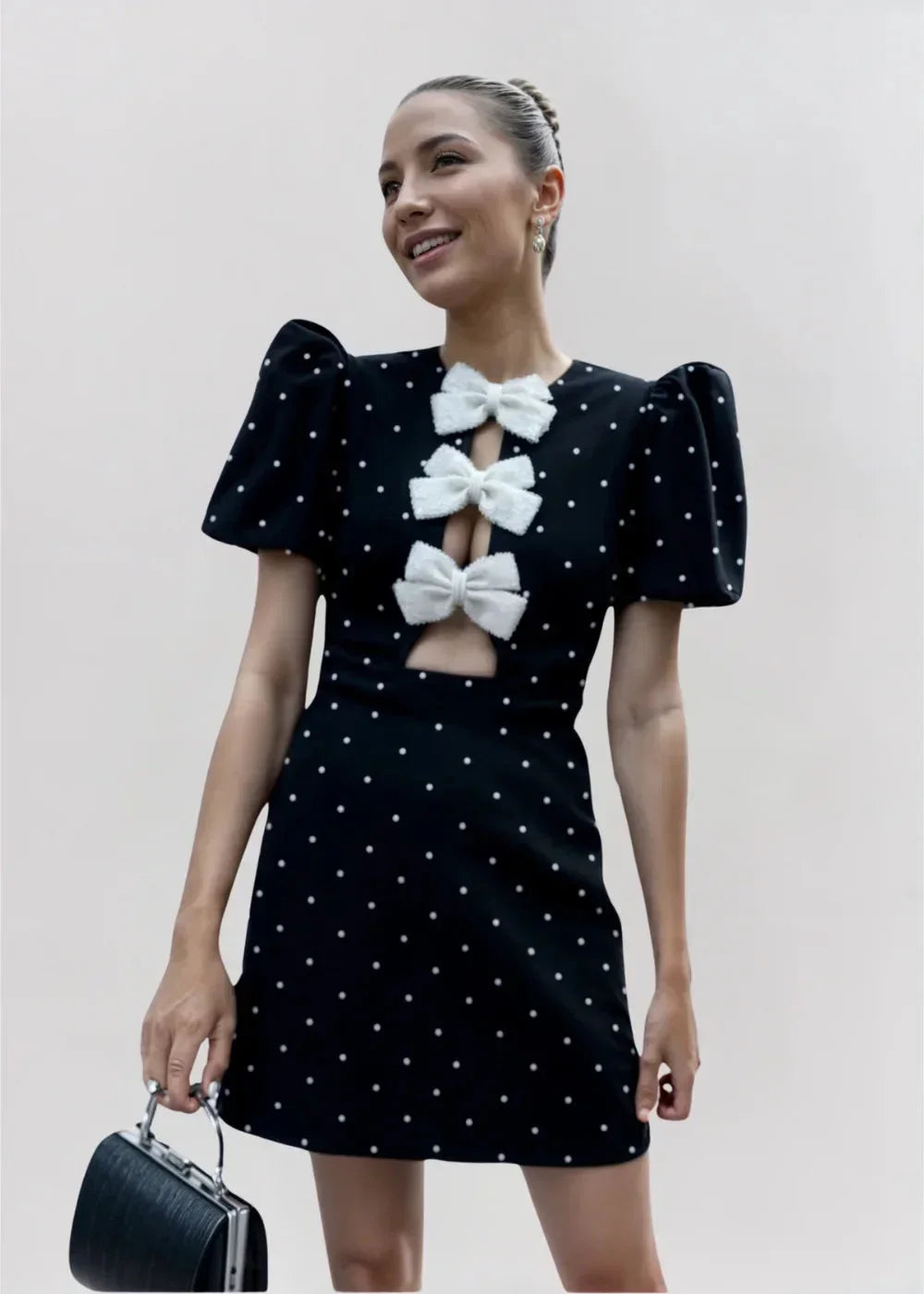 Robe courte à pois avec nœuds, manches bouffantes en tissu léger, parfaite pour une mini soirée élégante.