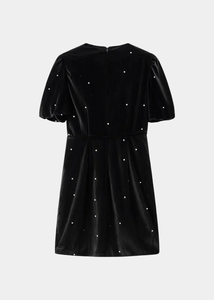 Robe courte à pois avec nœuds, manches bouffantes, en tissu léger, idéale pour une soirée. Design élégant et féminin.