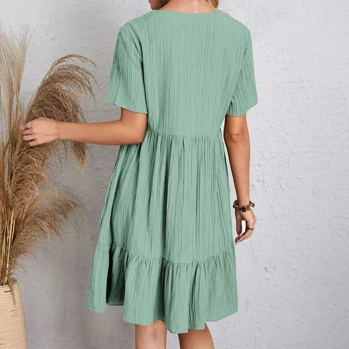 Robe courte en coton léger avec volant, col en V et manches courtes, idéale pour les journées d'été décontractées.