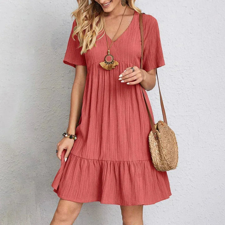 Robe courte en coton léger, volantée, col en V et manches courtes, idéale pour un look estival décontracté au quotidien.