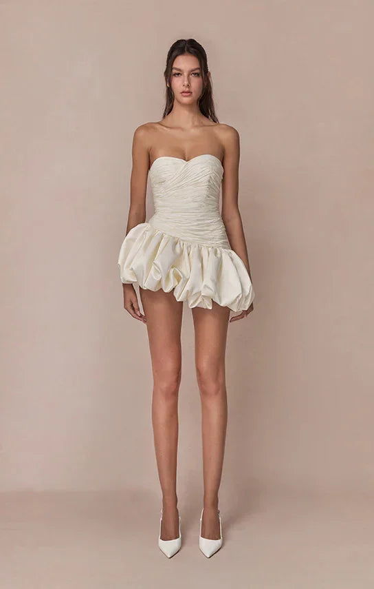 Robe de soirée femme en ivoire, drapée avec une coupe ballon, en tissu léger pour un look élégant et fluide.