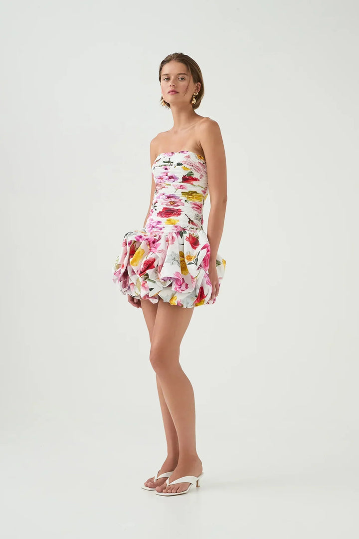 Robe de soirée femme blanche avec ourlet bulle, fabriquée en tissu léger, offrant une silhouette élégante et moderne.