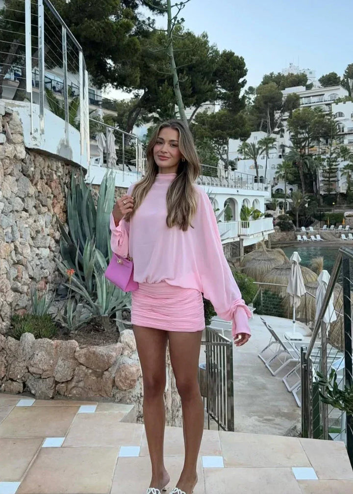 Robe de soirée rose pour femme, à manches longues, en tissu léger avec un décolleté en V et une taille cintrée.