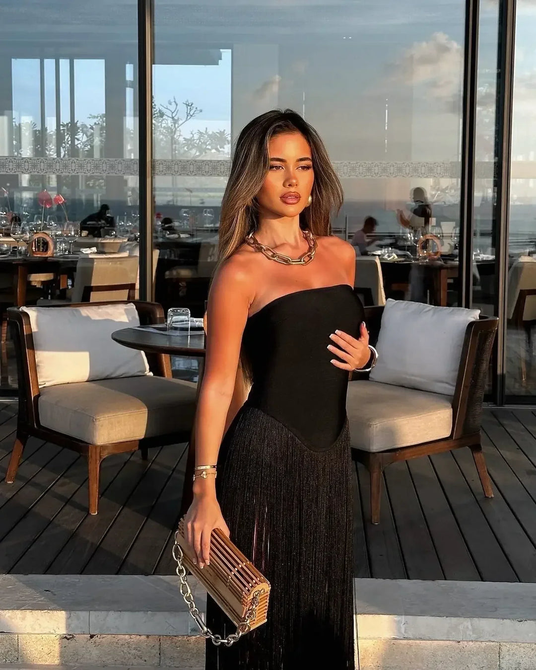 Robe noire en bandage avec franges, conçue pour un ajustement flattering, idéale pour les soirées d'été.