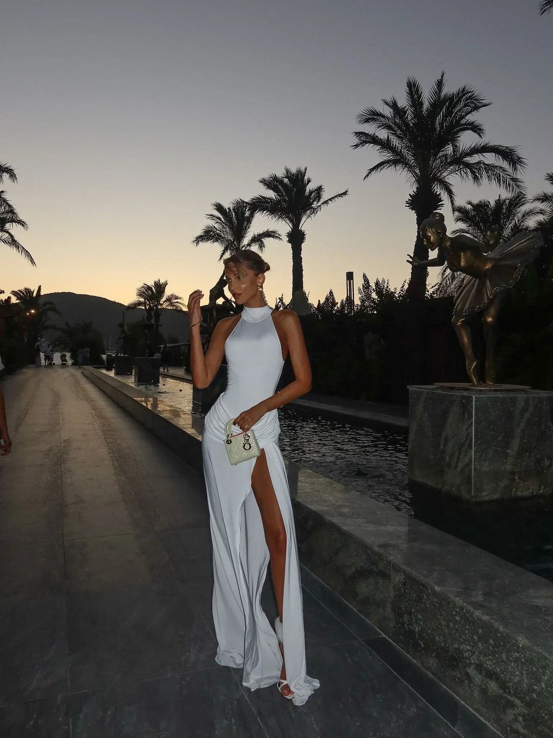 Robe d'été blanche pour femme, en coton léger, avec une fente haute pour une allure élégante et confortable.