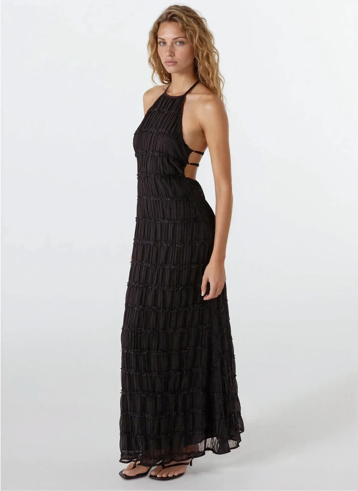 Robe d'été femme dos nu, en tissu texturé léger, avec un design fluide et des bretelles fines pour une allure décontractée.