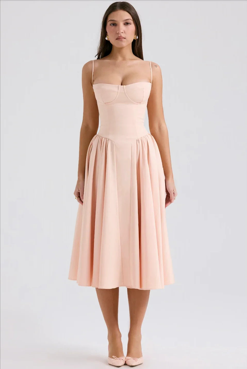 Robe d'été femme rose à encolure structurée, en tissu léger, avec un design fluide et sans manches.