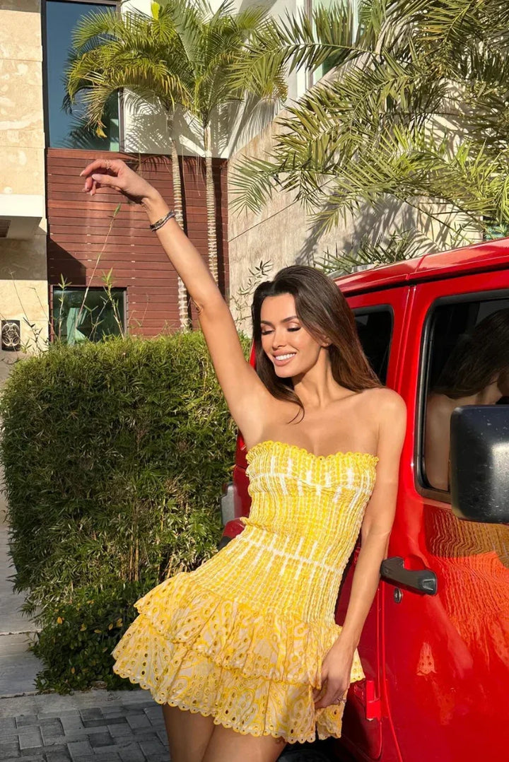 Robe d'été femme jaune à volants, en coton léger, avec un design à manches courtes et un motif floral subtil.