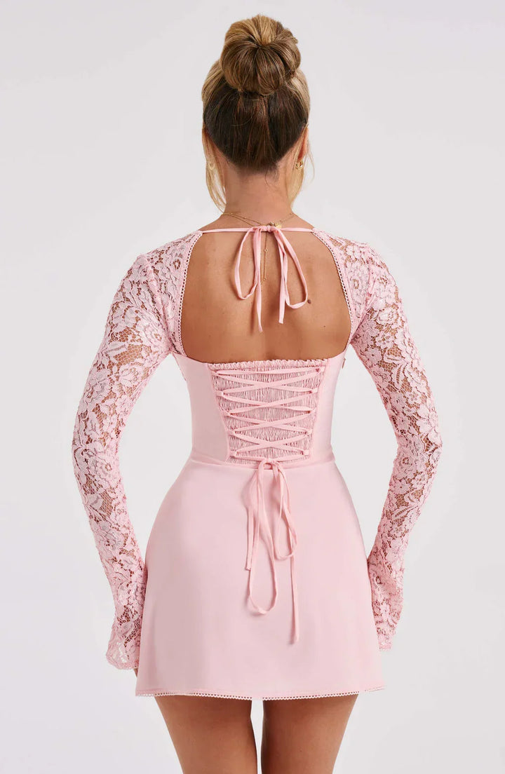 Robe d'été rose pour femme, en tissu léger avec manches en dentelle délicate et coupe fluide.
