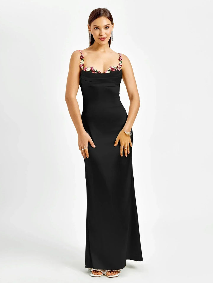 Robe longue ajustée sans manches en tissu léger, ornée de fleurs délicates pour une soirée élégante.