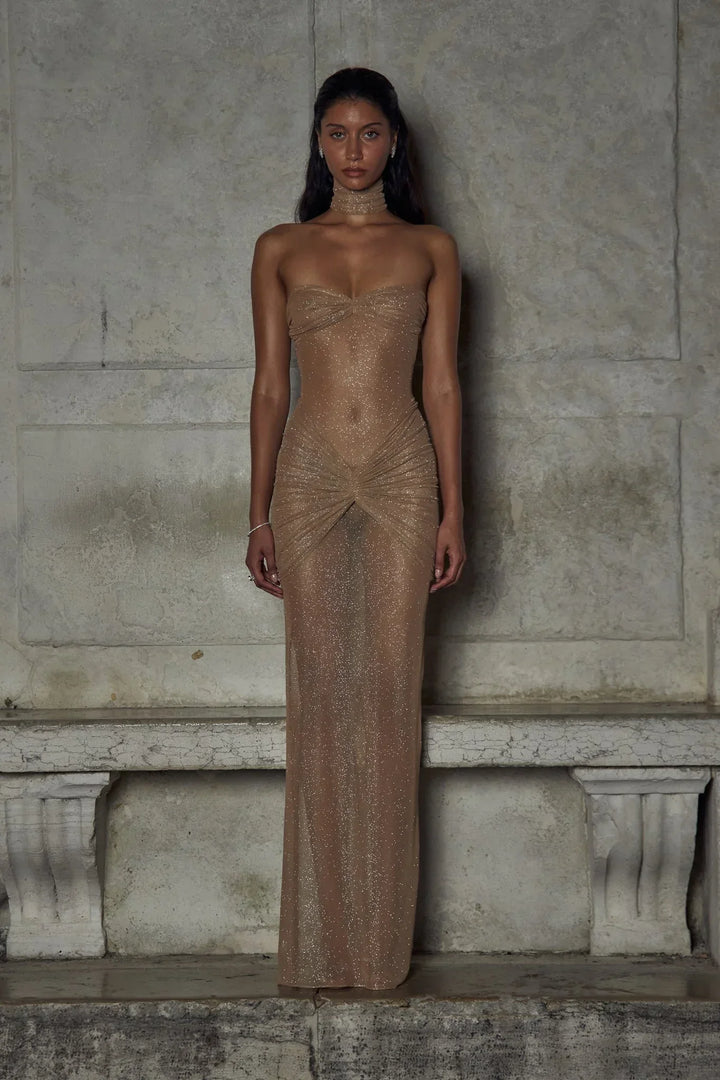 Robe longue beige sans bretelles en tissu scintillant avec plis élégants pour une soirée chic.