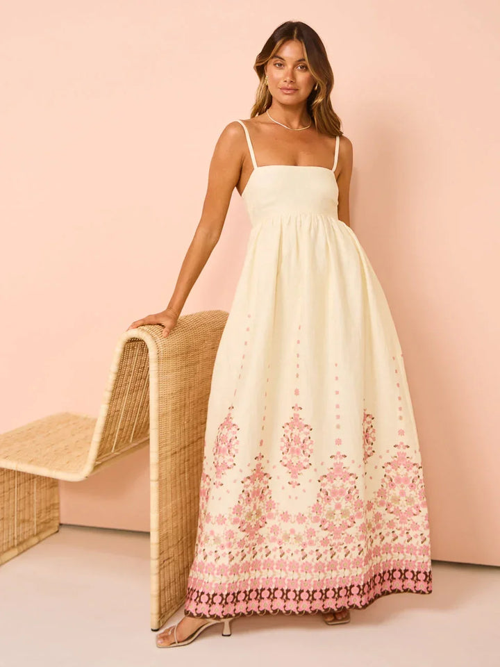Robe longue blanche en coton léger, motifs floraux colorés, ourlet détaillé, bretelles fines, idéale pour l'été.