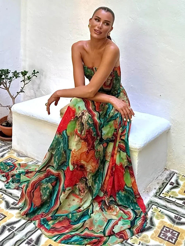 Robe longue pour femme, avec buste dénudé, imprimé multicolore en tissu léger et fluide, idéale pour les occasions estivales.