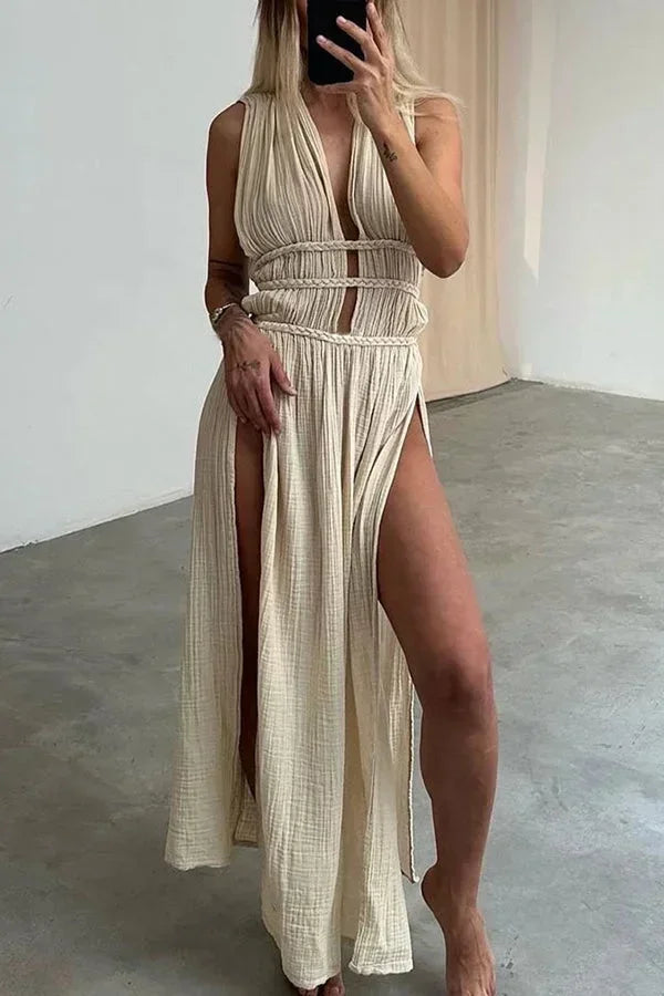 Robe longue beige à dos-nu, en tissu léger, avec découpes et fente élégante pour un look raffiné et moderne.
