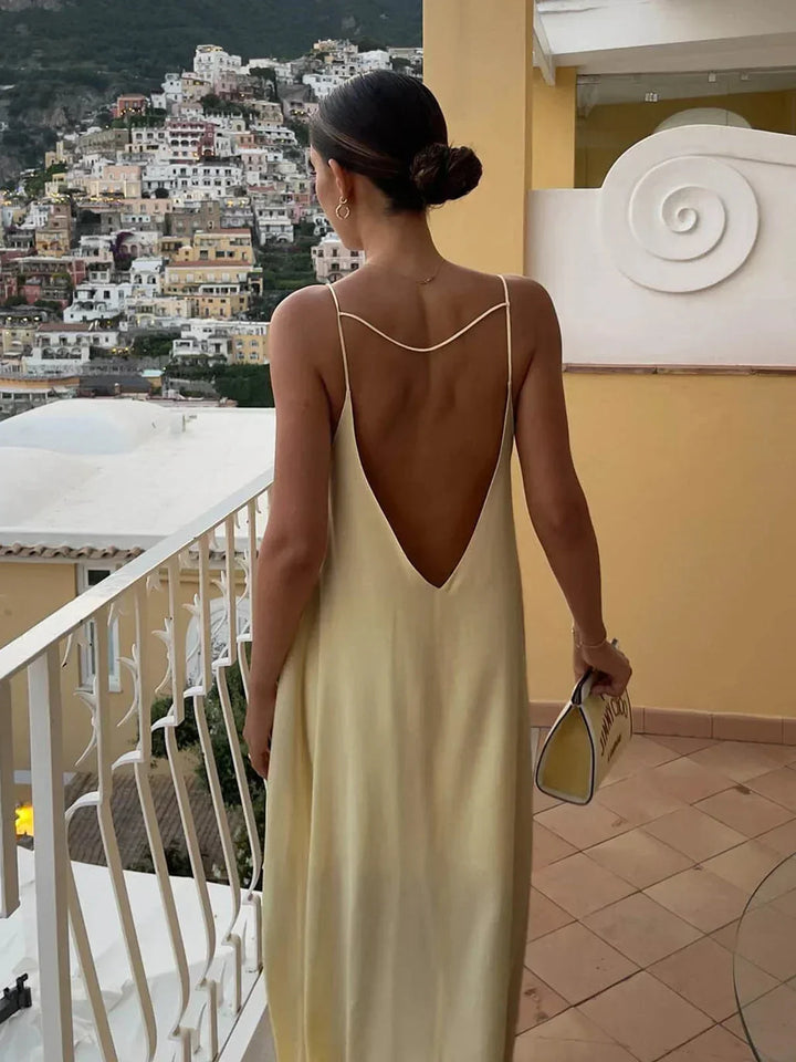 Robe longue jaune en tissu léger, dos nu avec fines bretelles, idéale pour les journées d'été ensoleillées.