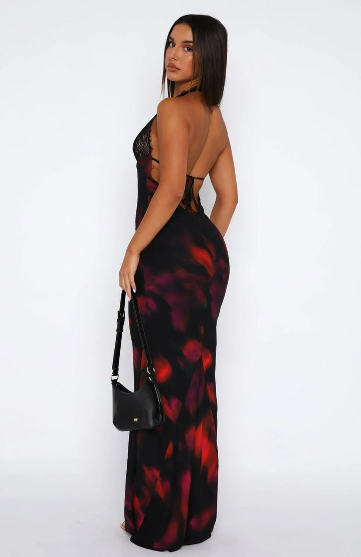 Robe longue noire dos nu en tissu léger, ornée de détails en dentelle avec un imprimé coloré vibrant.