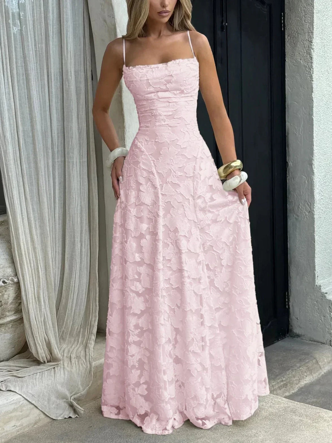 Robe longue rose pour femme, légère, en tissu fluide, avec bretelles fines et motif floral délicat.