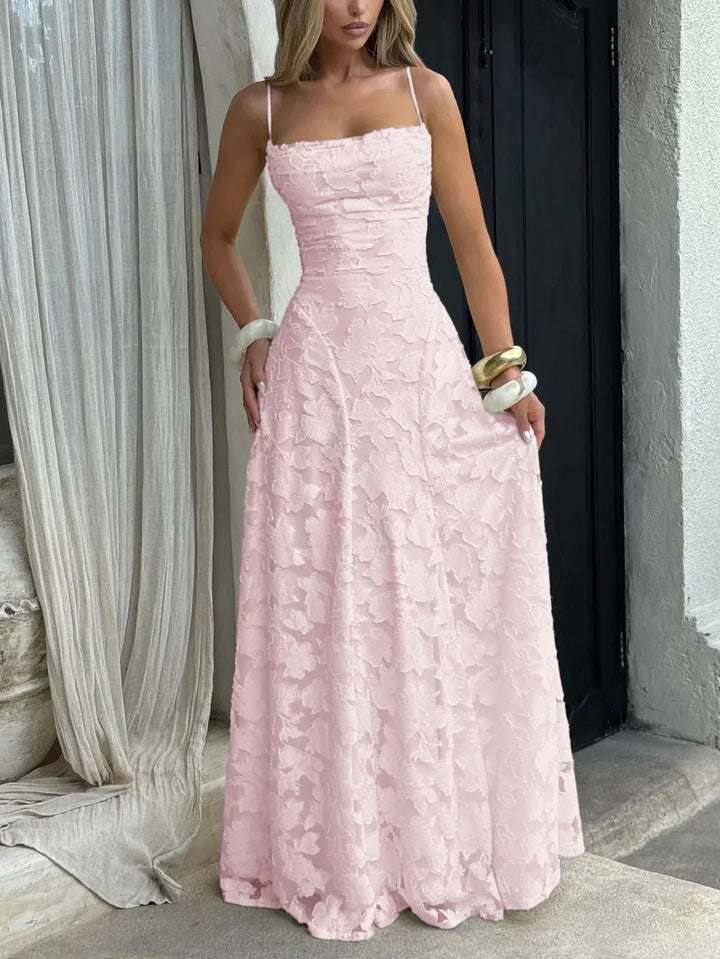 Robe longue rose pour femme, légère, en tissu fluide, avec bretelles fines et motif floral délicat.