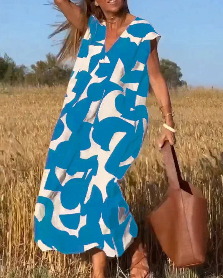 Robe longue bleue pour femme, col V avec motifs fluides, en chiffon léger pour une allure décontractée et élégante.