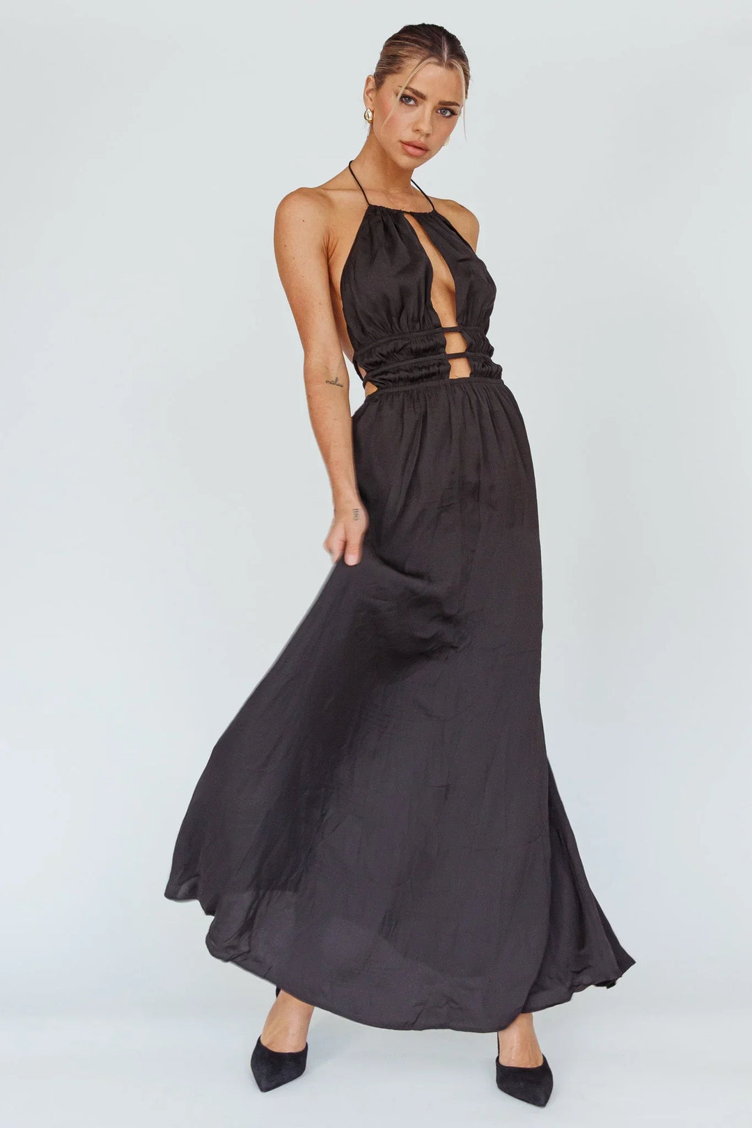 Robe longue femme en tissu léger, avec un dos nu et des découpes élégantes. Idéale pour des occasions estivales.
