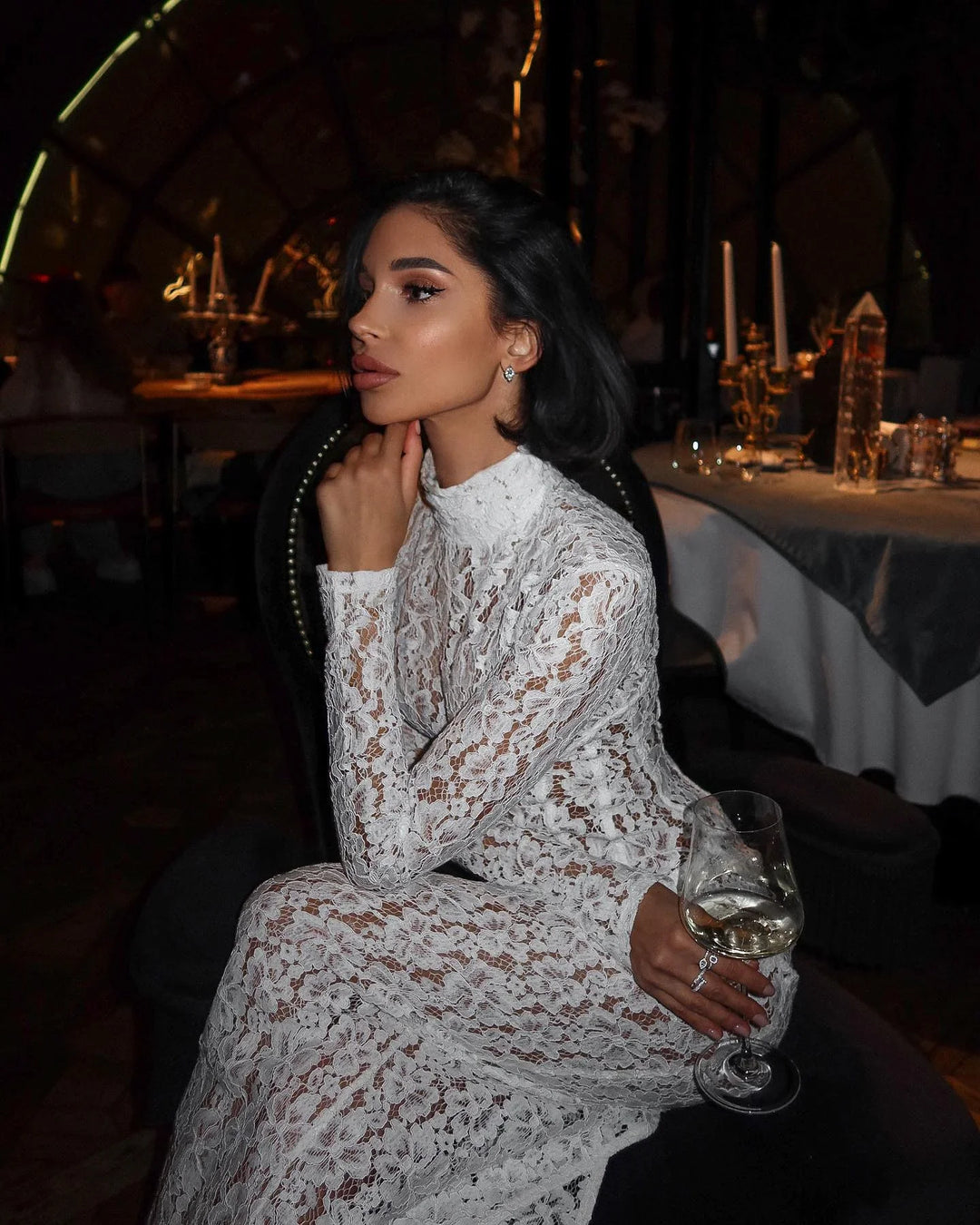 Robe longue blanche en dentelle, avec des manches délicates et une taille cintrée, idéale pour les occasions spéciales.