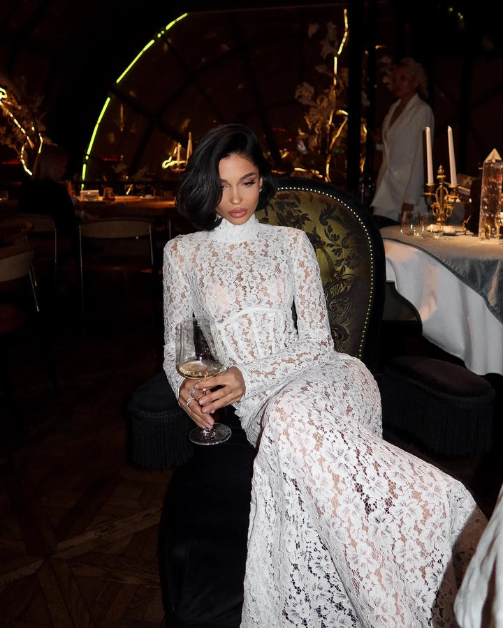 Robe longue blanche en dentelle, manches courtes, corsage ajusté et jupe évasée pour un look élégant et intemporel.
