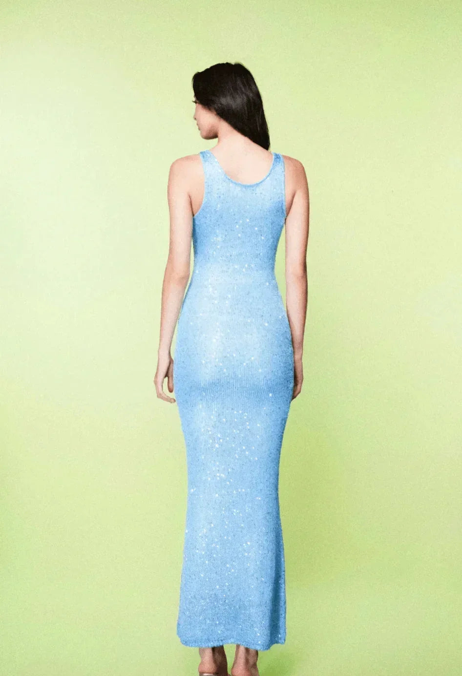 Robe longue sans manches en tissu léger bleu glacé, silhouette ajustée avec des découpes élégantes.
