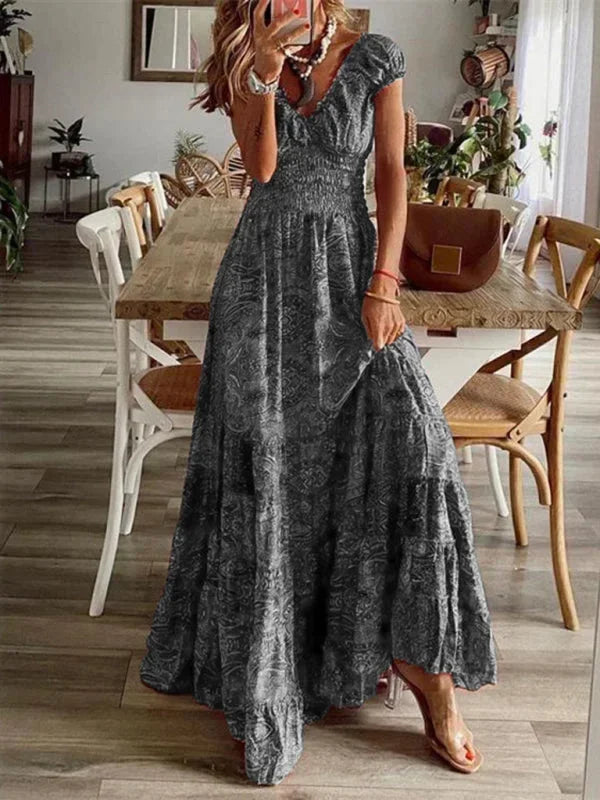 Robe longue grise bohème en tissu léger, avec volants délicats et col en V, idéale pour un style décontracté.