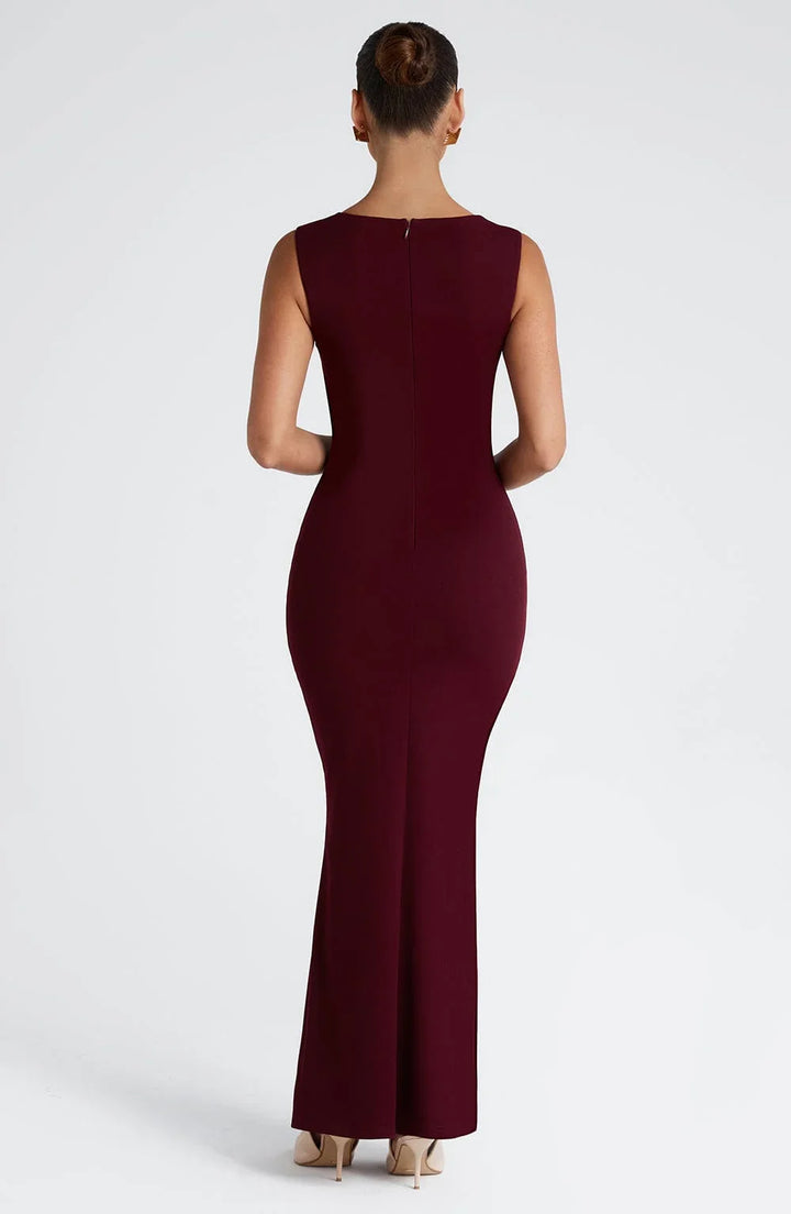 Robe longue bordeaux sans manches, en tissu fluide, avec un design simple et élégant, idéale pour des occasions spéciales.