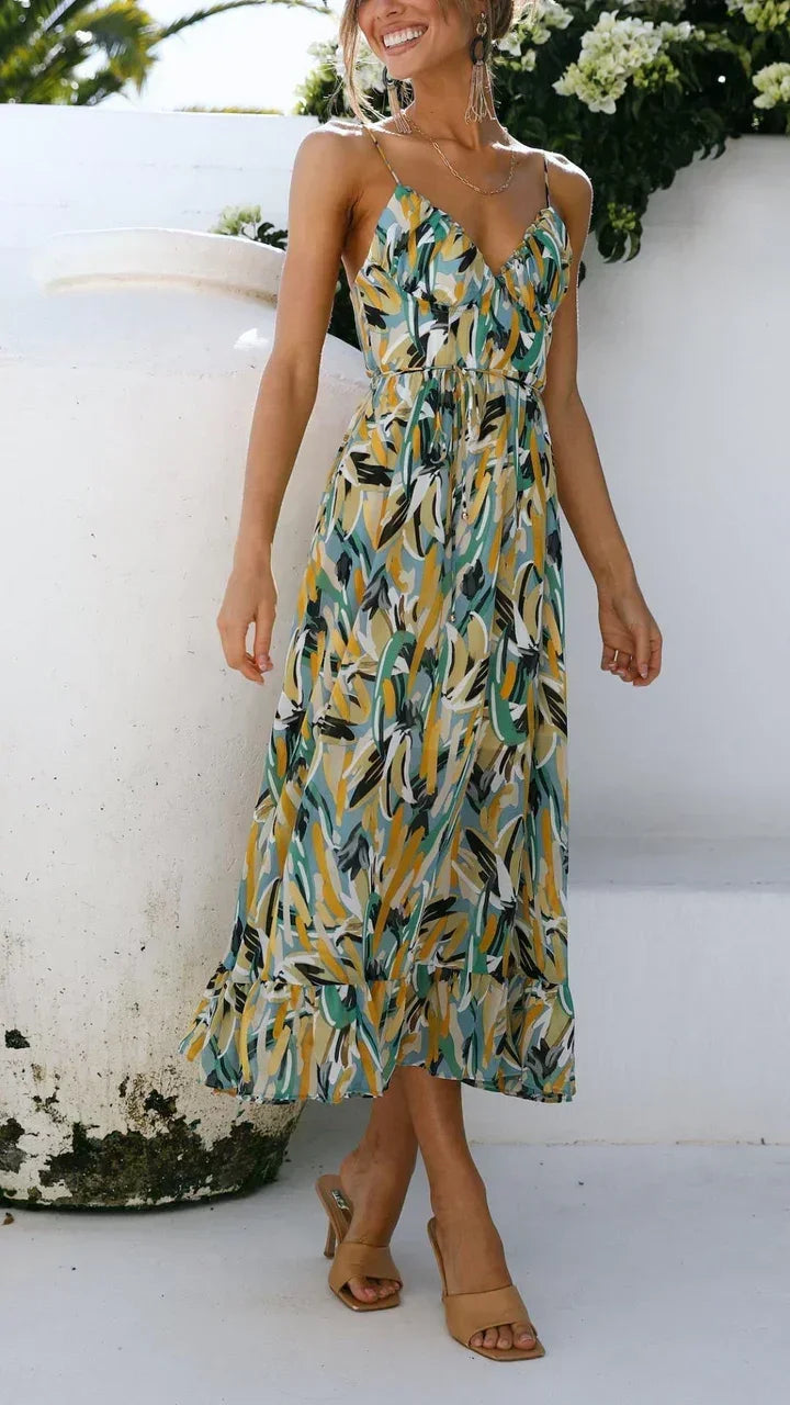 Robe longue à bretelles fines avec un imprimé végétal, confectionnée en tissu léger et fluide, idéale pour l'été.