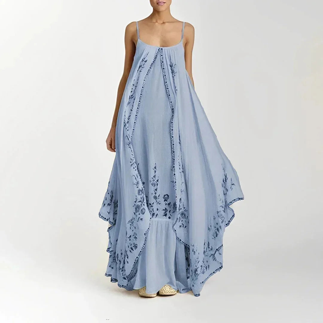 Robe longue bleue à bretelles fines, en tissu léger avec motifs floraux délicats, idéale pour les journées d'été.