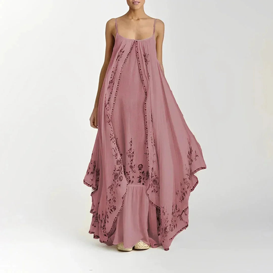 Robe longue rose à bretelles fines, en tissu léger avec motifs floraux délicats pour un look élégant et féminin.
