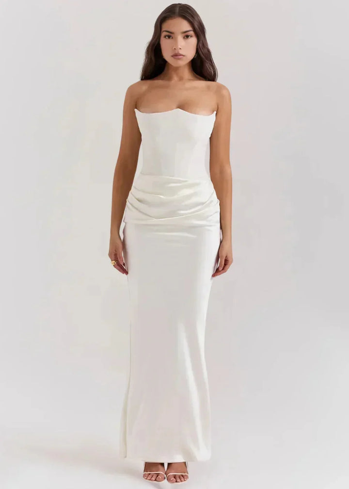 Robe longue blanche en satin, avec bustier froncé, idéale pour les soirées élégantes. Détails fluides et modernes.