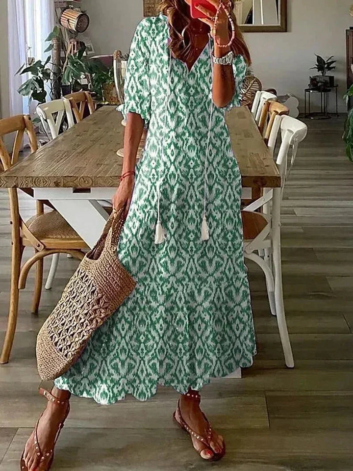 Robe longue en vert, col en V, motifs floraux, tissu léger, parfaite pour les occasions estivales.