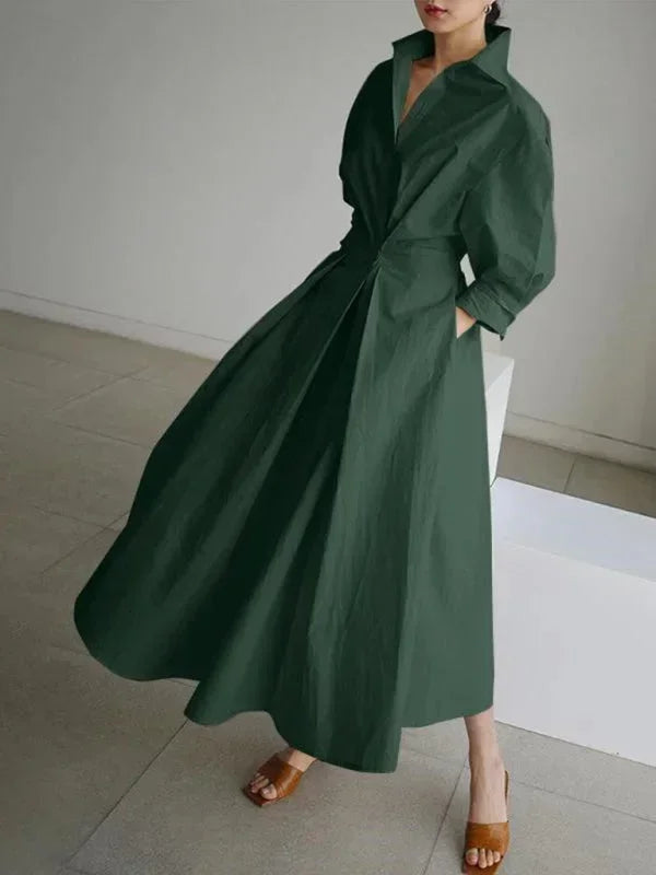 Robe longue verte claire en tissu léger, col fluide, manches, et poches pratiques pour un look décontracté.