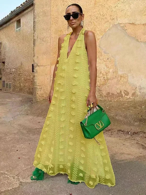 Robe longue jaune pour femme, col halter, fabriquée en tissu léger, avec des détails floraux pour un look élégant.