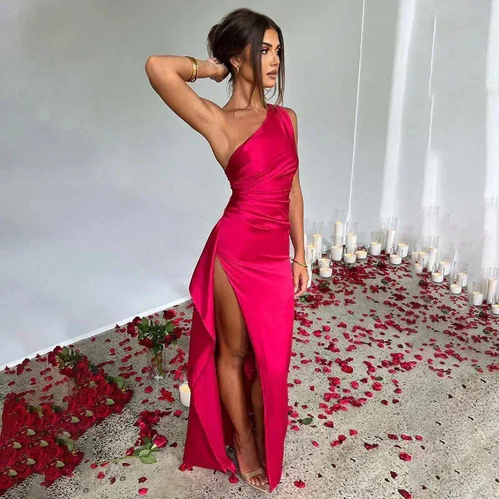 Robe longue femme en satin rose foncé, fendue sur une épaule, avec une coupe élégante et fluide.
