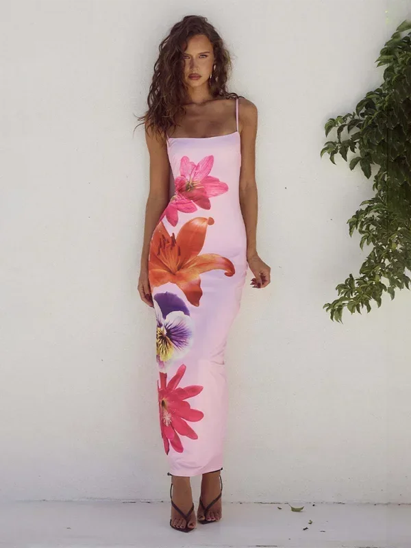 Robe longue femme en tissu léger, à fines bretelles, avec un imprimé floral délicat sur fond rose. Idéale pour l'été.