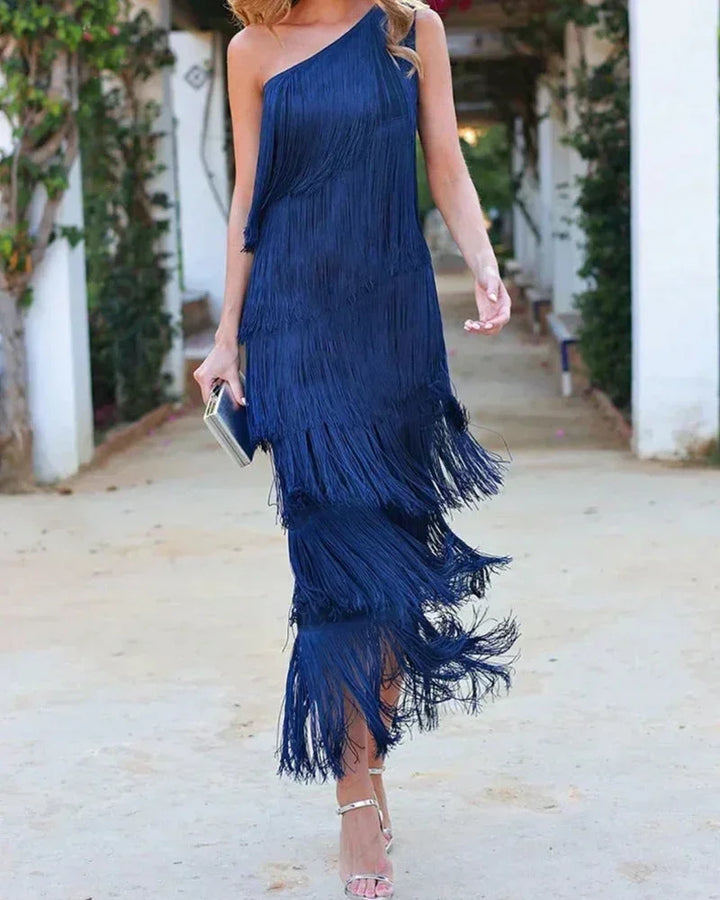 Robe longue femme avec franges et encolure asymétrique, en tissu léger et flowy, idéale pour une tenue estivale.