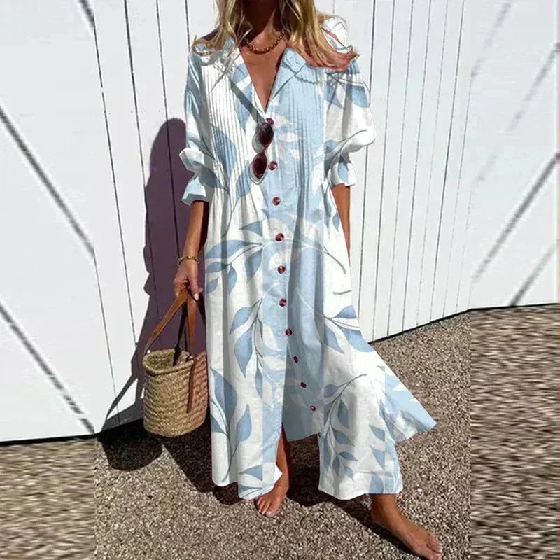Robe longue femme en bleu clair, imprimé floral, col V et manches mi-longues, en tissu léger et fluide.