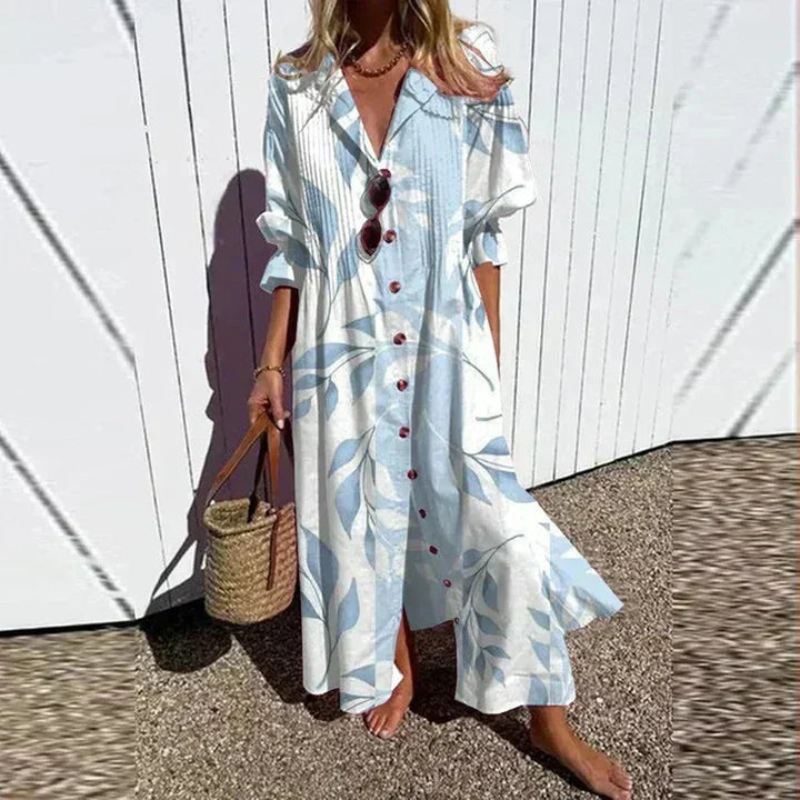 Robe longue femme en bleu clair, imprimé floral, col V et manches mi-longues, en tissu léger et fluide.