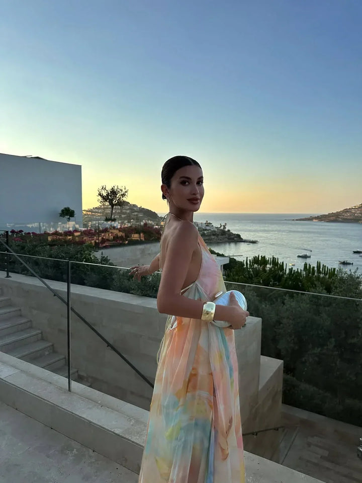 Robe longue femme imprimée, dos nu en coton léger, avec un motif floral coloré et une coupe fluide pour un confort optimal.