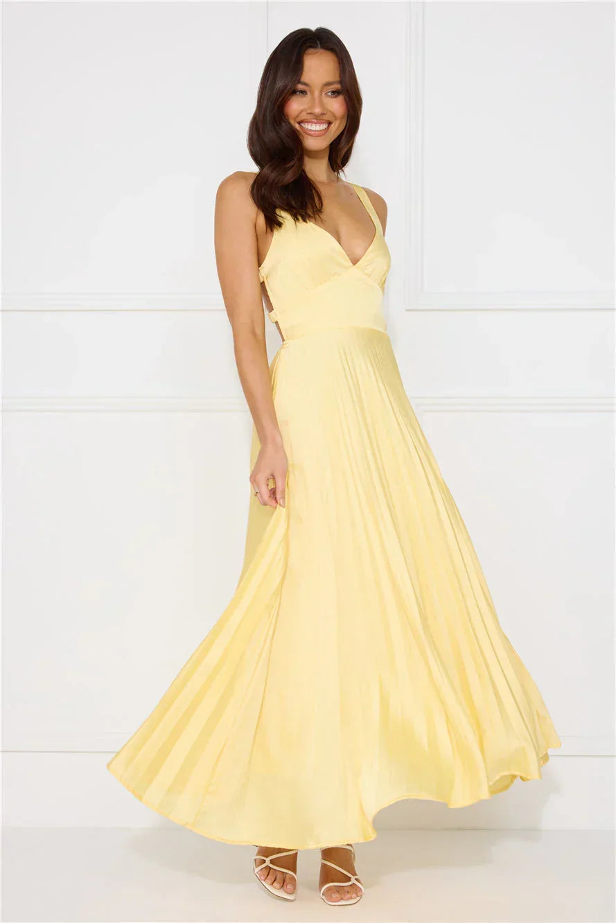 Robe longue femme jaune plissée en polyester, avec une coupe fluide et des détails de plis sur toute la longueur.