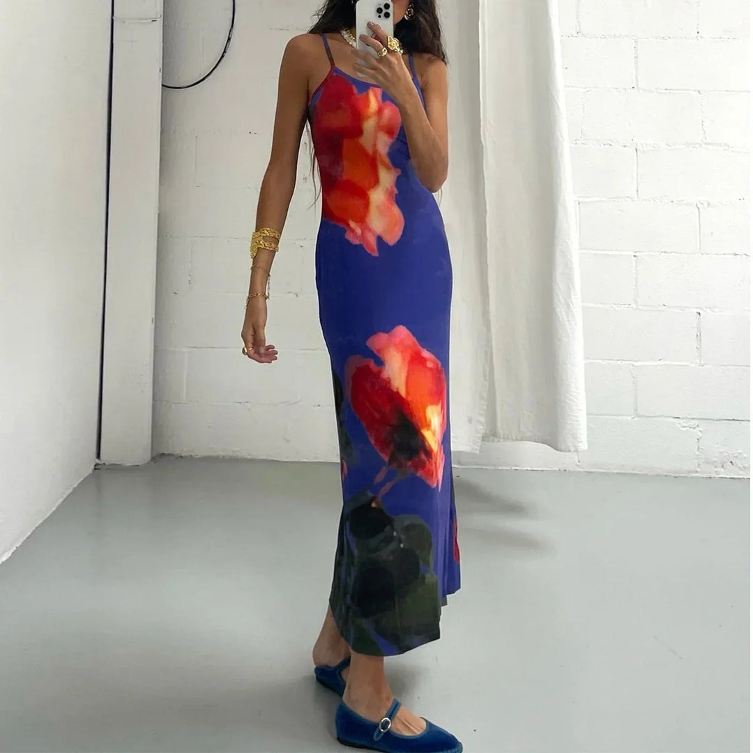 Robe longue bleue en tissu léger avec bretelles fines et motifs artistiques colorés, idéale pour les occasions décontractées.