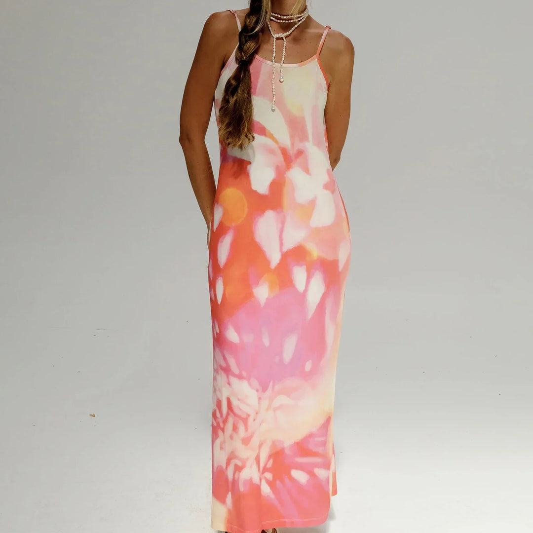 Robe longue rose avec motifs artistiques, bretelles fines, en tissu léger et fluide, idéale pour les journées ensoleillées.