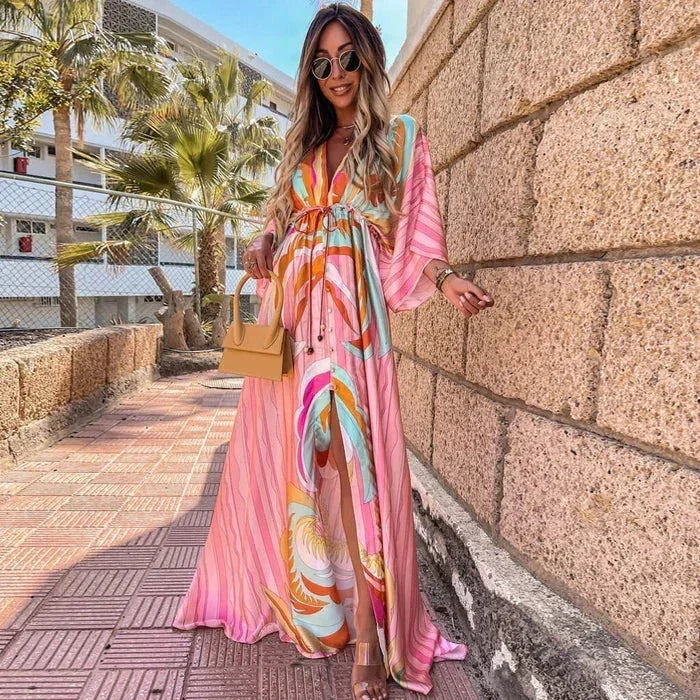Robe longue femme en rose clair, dotée de motifs élégants, ceinture cintrée et manches longues pour un look raffiné.