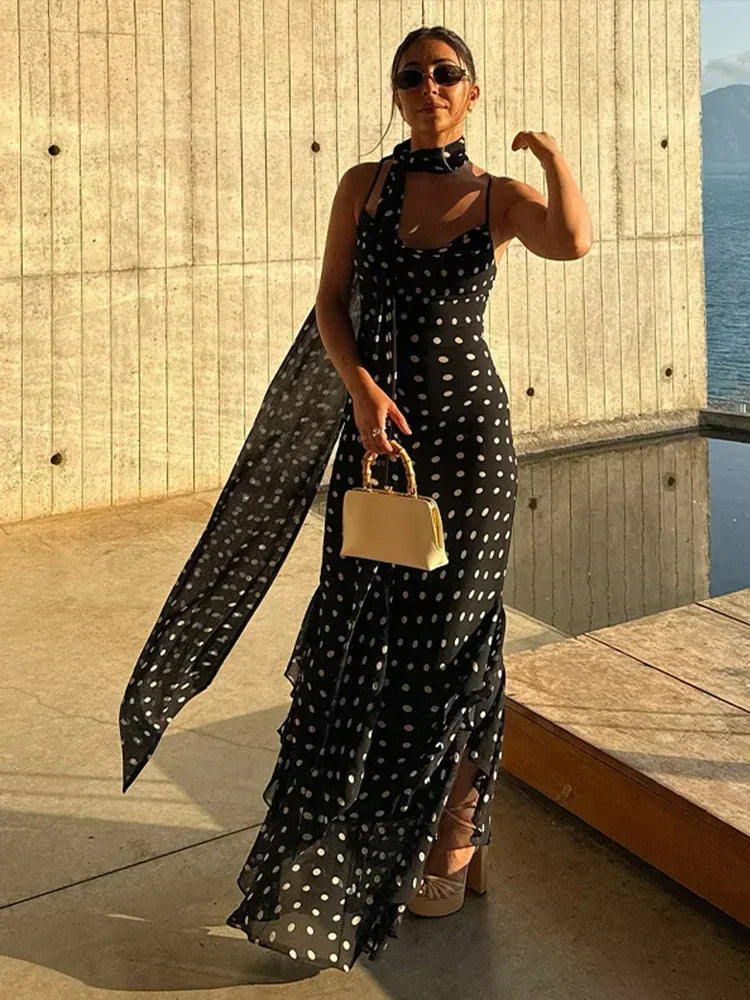 Robe longue noire à pois, en polyester léger, avec manches courtes et ceinture ajustable pour un look élégant et confortable.